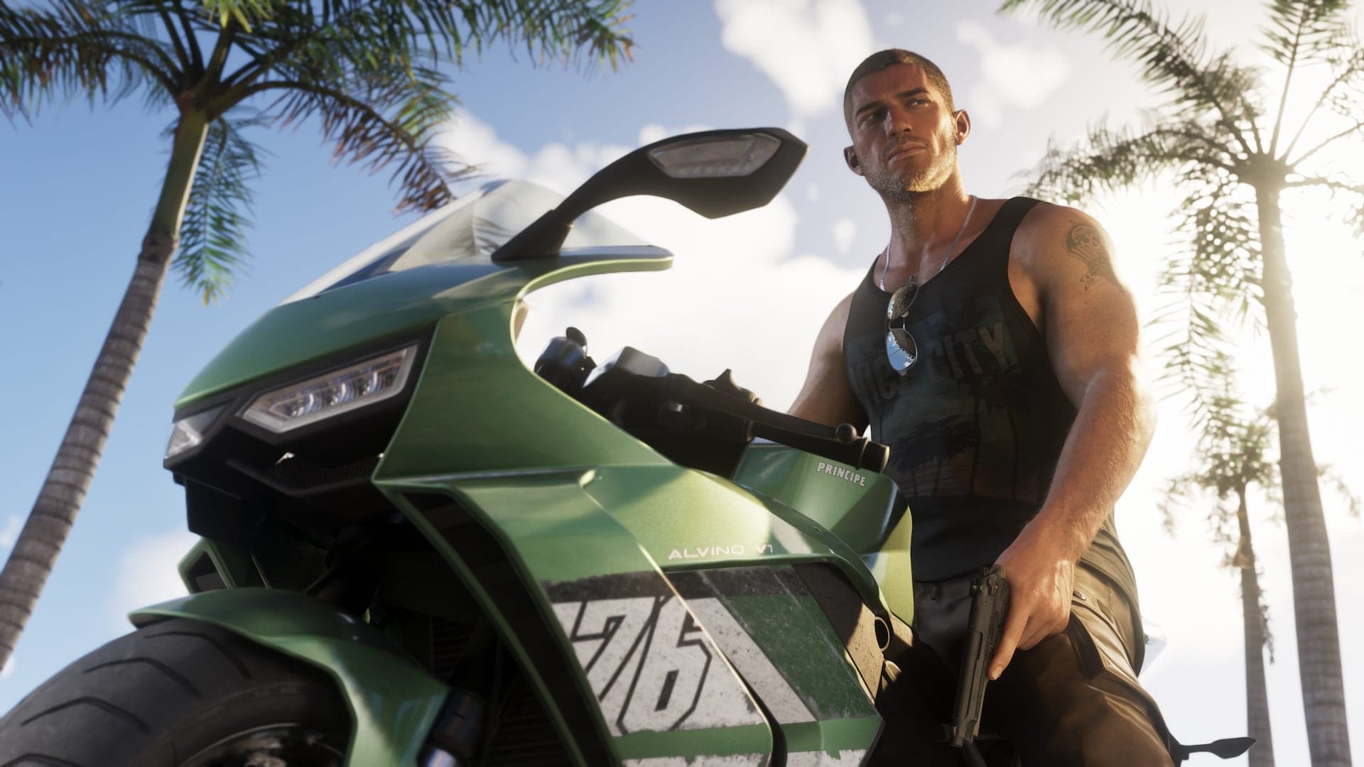 Jason Duval standing beside a green sport motorcycle under palm trees in bright sun.