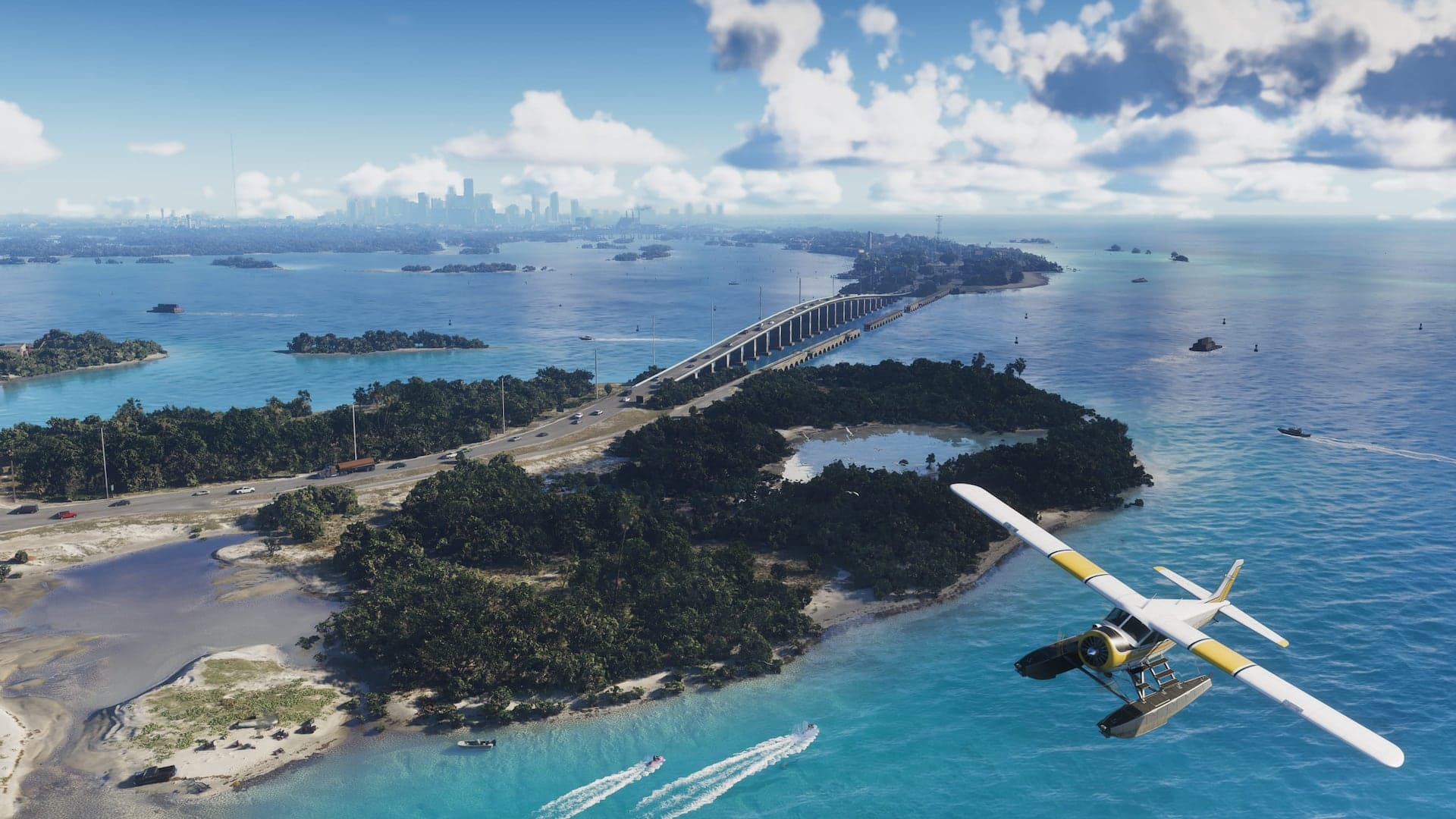 An aerial view of a causeway bridge crossing turquoise water between mangrove islands, with a seaplane banking in the foreground and a city skyline on the horizon.