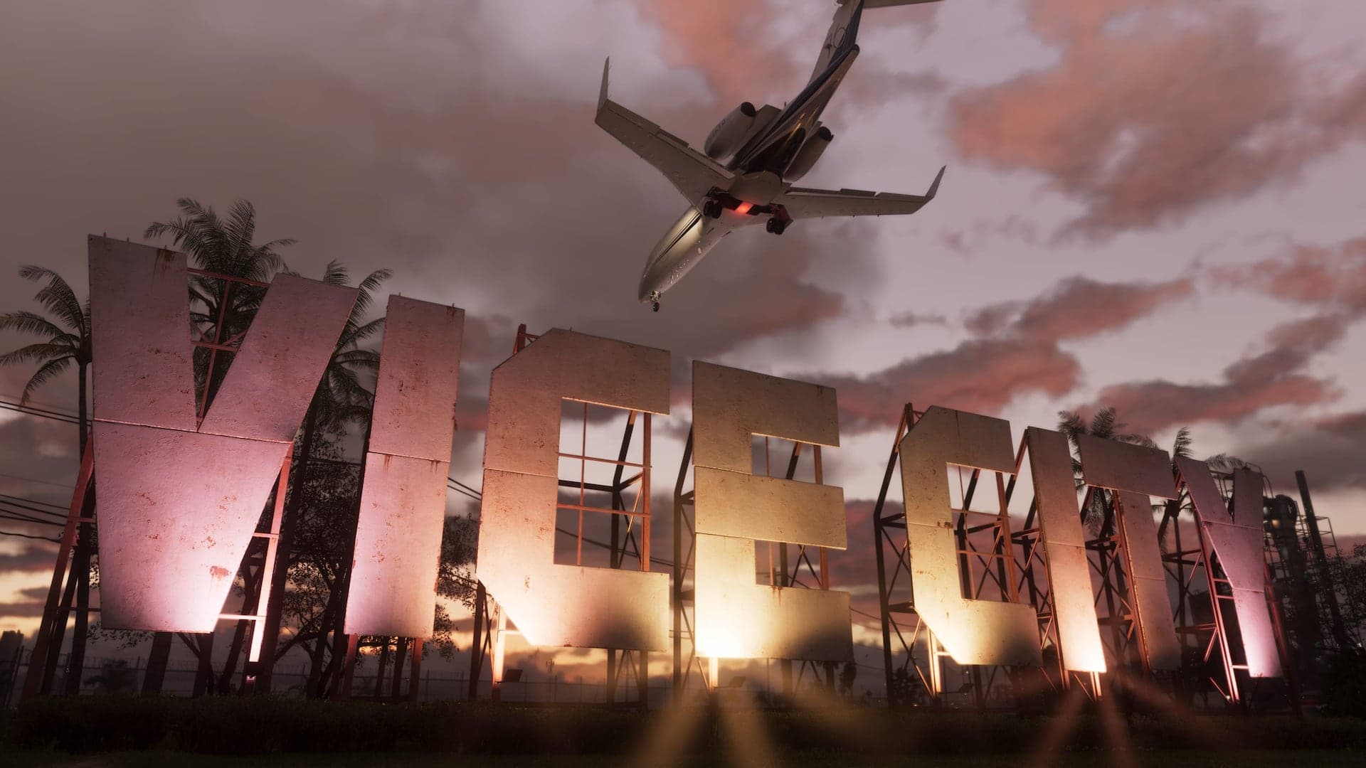 A huge weathered VICE CITY sign lit from below at dusk, with a private jet passing low overhead.